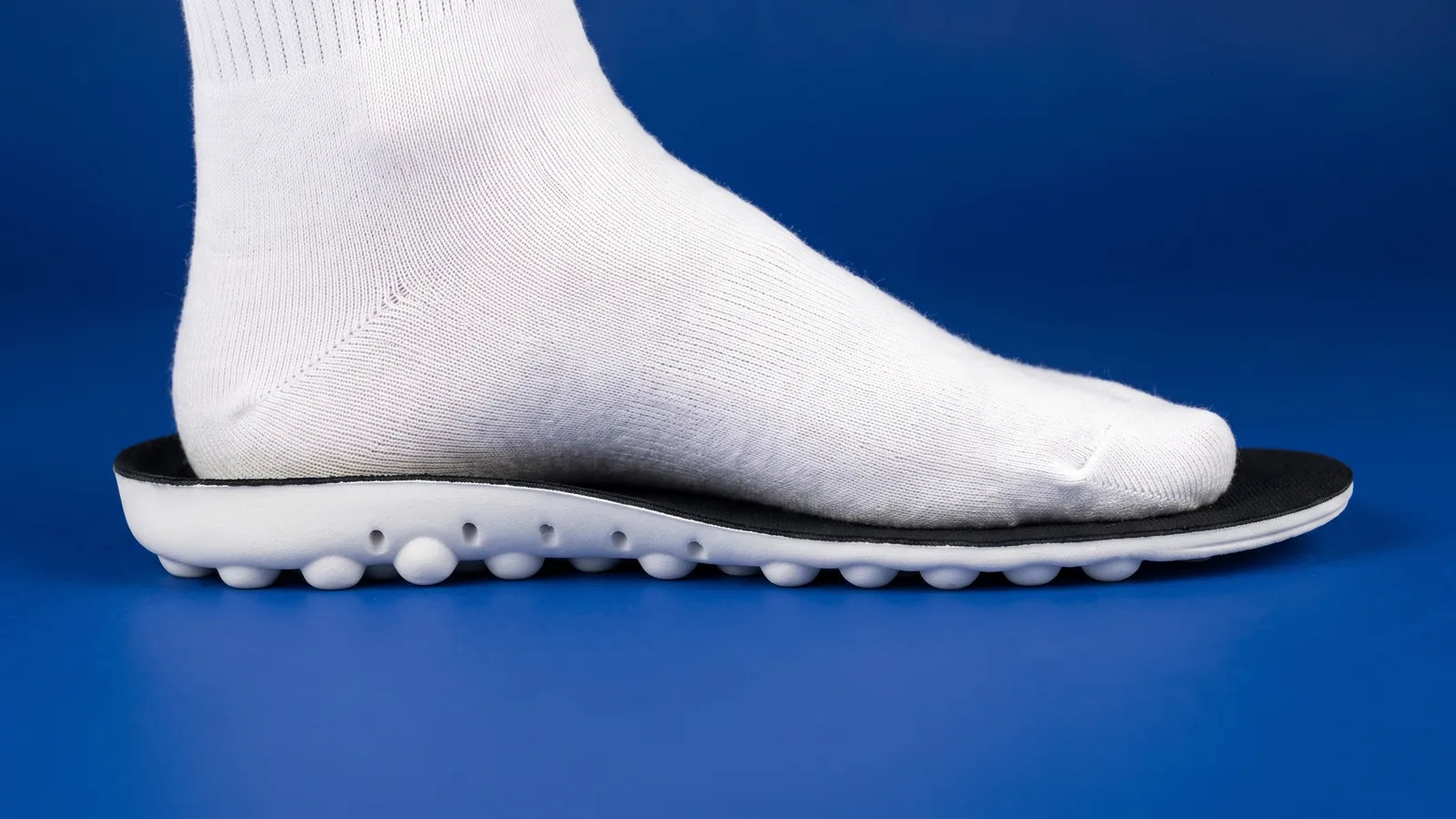 Pied en chaussette posé sur la face à picots de la semelle Ortholimit